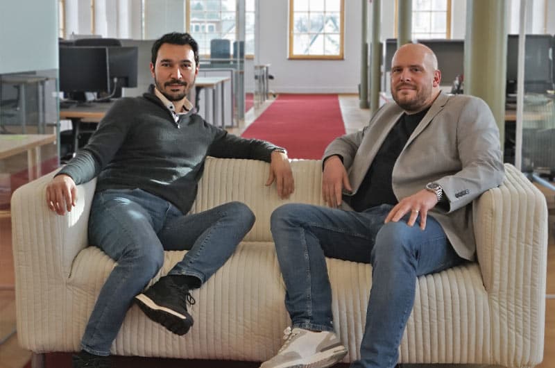 reybex-Geschäftsführer Selçuk Acar und secupay-Partnermanager Patrick Frisch gemeinsam auf einem Sofa